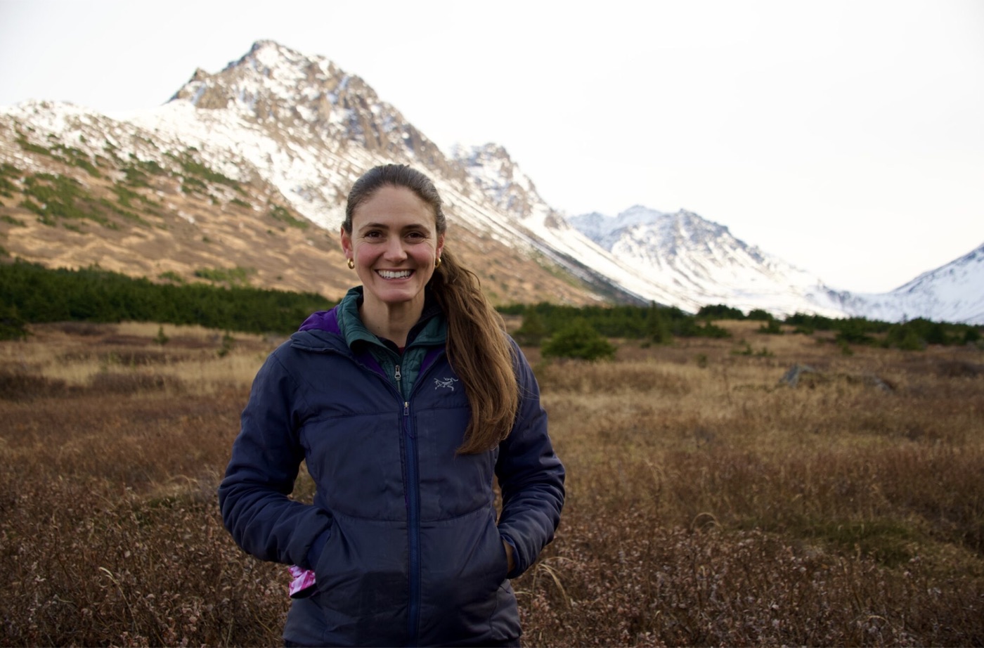 Diana Saverin standing in an autumn valley below snowy Alaska mountains
